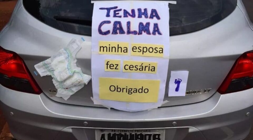 Pai cola cartaz e fralda no carro para pegar estrada após nascimento de bebê